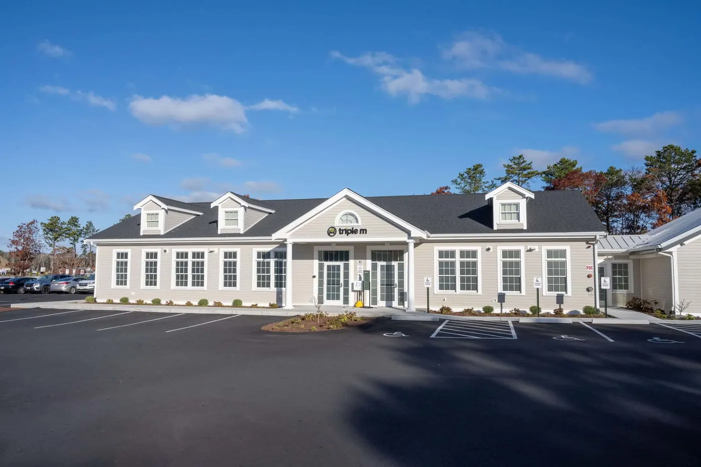 Triple M Mashpee storefront, a two-story white clapboard building with a paved lot on Echo Road